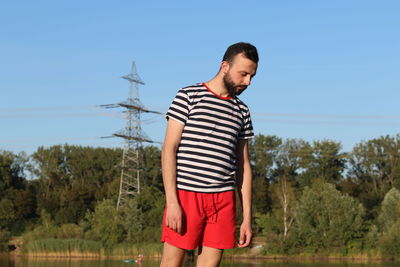 Full length of young man standing against sky