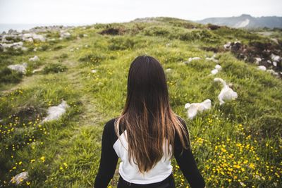 Rear view of woman standing on field