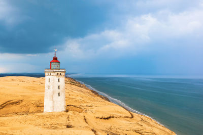 Rabjerg mile a lighthouse on the danish coast with storms clouds in the sky