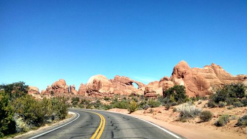 Road by rock formations at arches national park