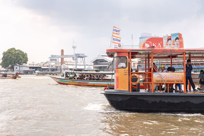 Boat in river against sky in city