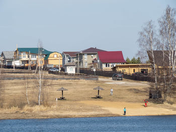 Houses by building against clear sky