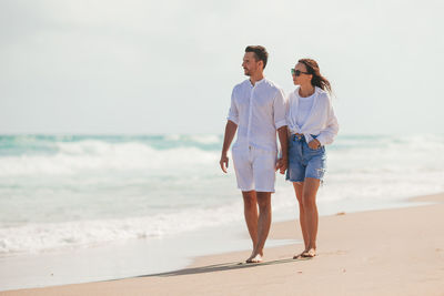 Rear view of couple standing at beach