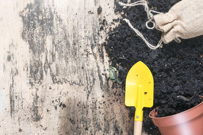 Close-up of shovel and dirt over wooden table