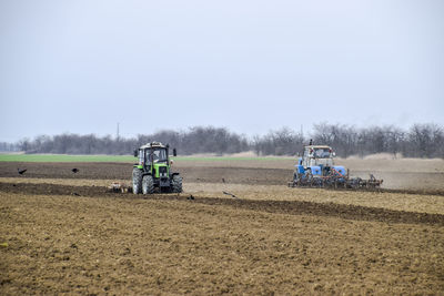 Tractor on agricultural field against sky