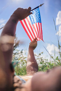 National flag day celebration. little patriot sitting on meadow and holding national flag of usa