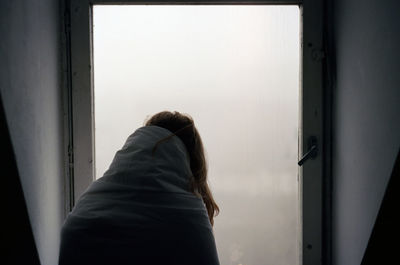 Person looking through window