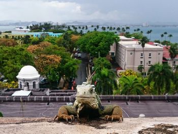 Statue in city against sky