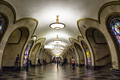 People walking in illuminated corridor