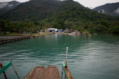 Scenic view of river by tree mountains