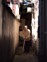 Man standing on footpath amidst buildings