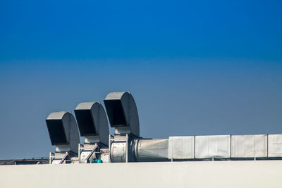 Low angle view of factory against clear blue sky