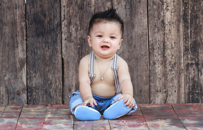 Cute baby boy against on wooden table