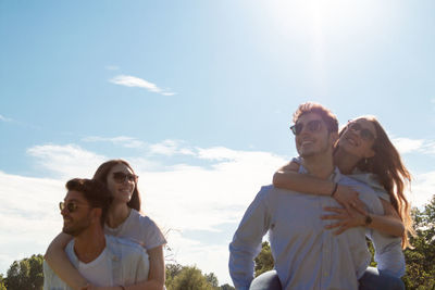 Young couple kissing against sky