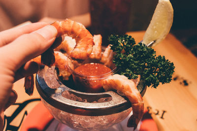 Cropped image of hand holding prawns
