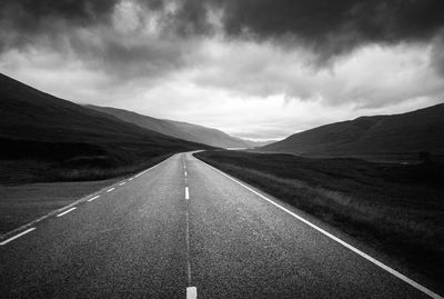 Empty road along countryside landscape