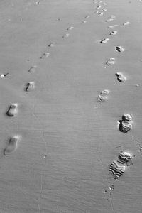 Close-up of footprints on sand at beach