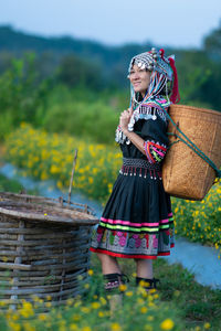 Woman holding umbrella standing against plants