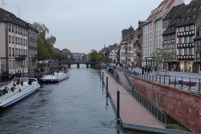 Canal amidst buildings in city against sky