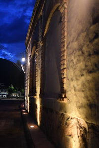 Narrow alley amidst buildings in city at night