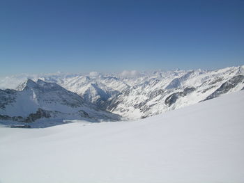 Scenic view of snowcapped mountains against clear blue sky