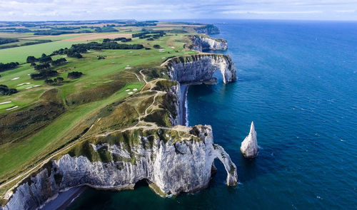 High angle view of sea by landscape against sky