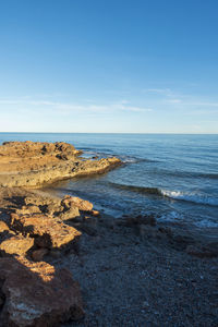 Scenic view of beach against blue sky