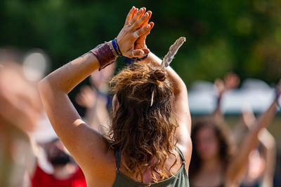 Rear view of woman with arms raised in background