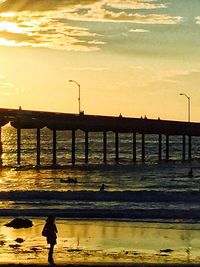 Pier in sea at sunset