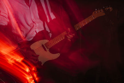 Blurred scene of guitar player playing an electric guitar on stage