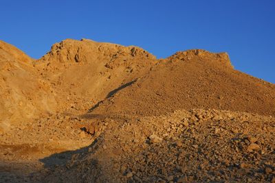 Scenic view of desert against clear blue sky