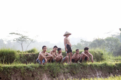 Group of people on field against sky