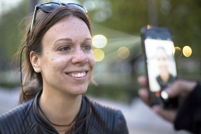 Portrait of smiling young woman using mobile phone