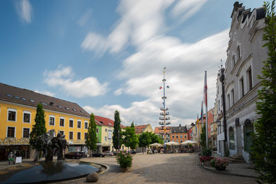 Street amidst buildings against sky in city