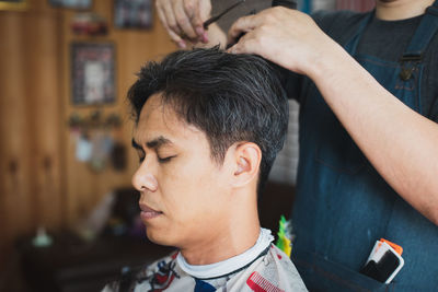 Midsection of barber cutting hair of customer