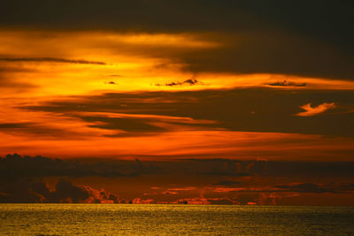 Scenic view of dramatic sky over land during sunset