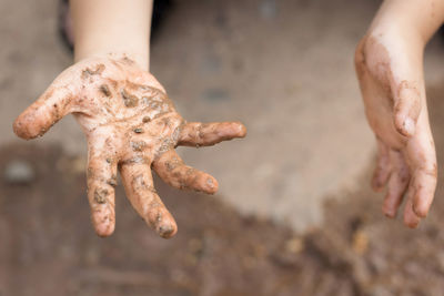 Close-up of human hand on sand