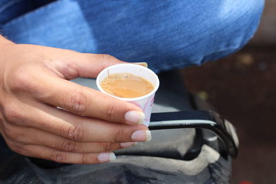 Midsection of woman holding coffee cup