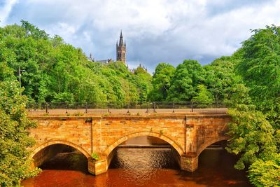 Arch bridge over river against sky