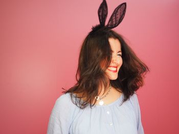Portrait of smiling woman against red background