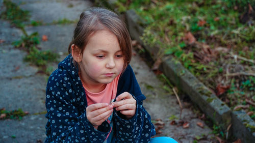 High angle view of thoughtful girl sitting outdoors