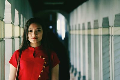 Portrait of young woman standing in corridor