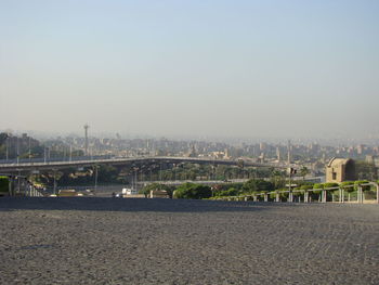 Bridge over river in city against clear sky