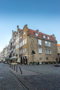 Buildings in city against clear blue sky