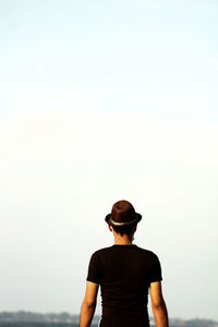 Rear view of man looking at sea against sky