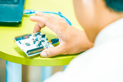 Midsection of man holding computer chip