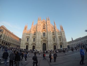 People walking by duomo milan against clear sky