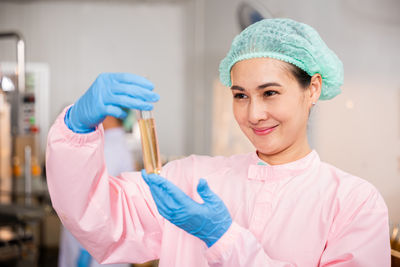 Portrait of young woman holding dentures