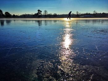 Scenic view of frozen lake against sky at sunset