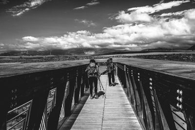 Footbridge over sea against sky